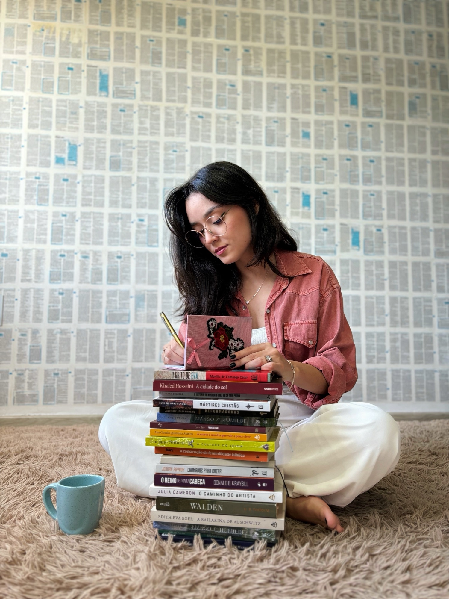 vanessa campos escrevendo sobre pilha de livros